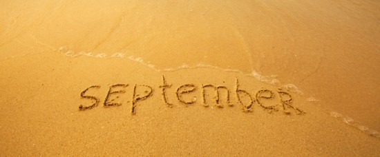 September - written in sand on beach texture - soft wave of the sea (months year series)
